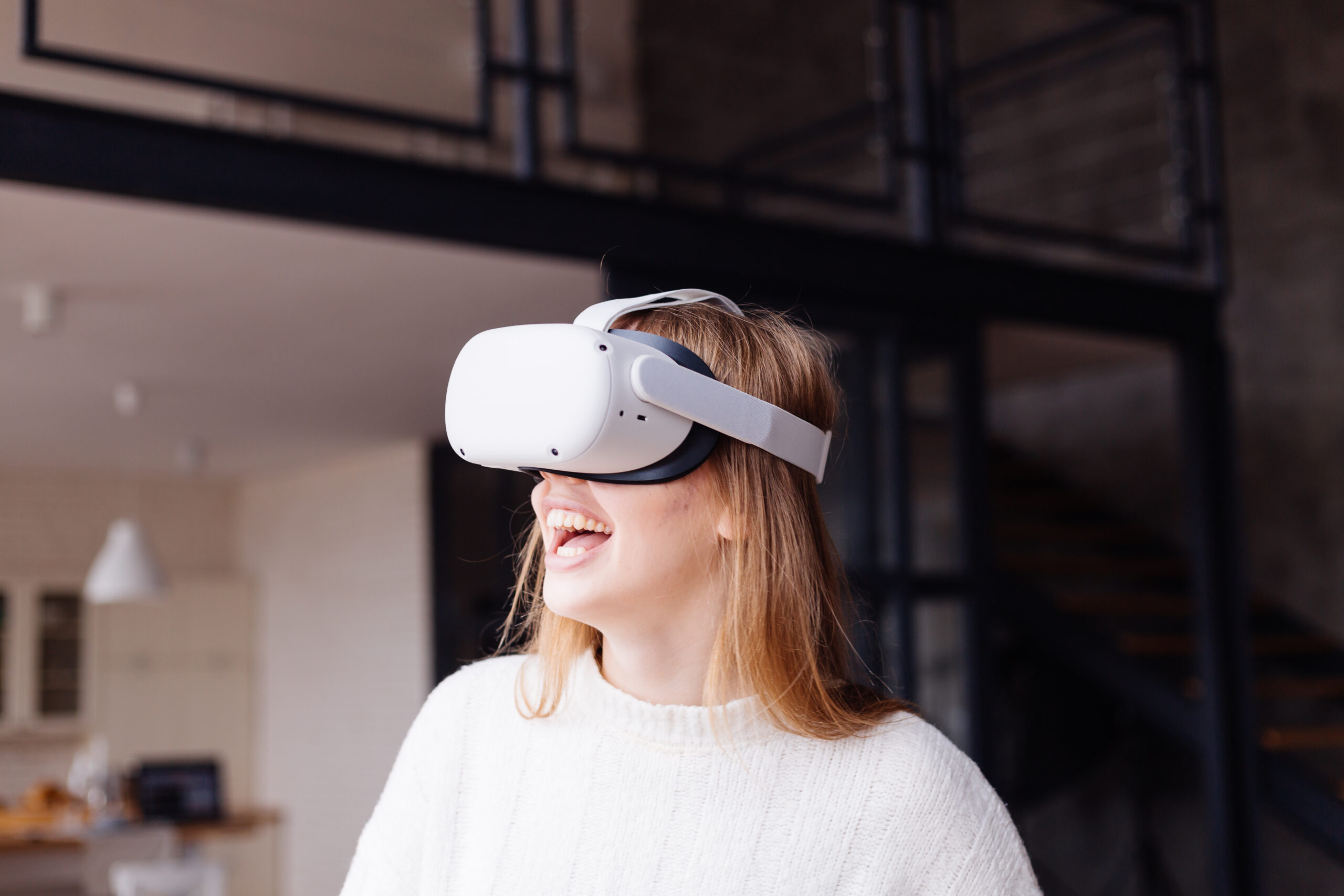 Young pretty girl at home playing vr games in virtual reality glasses, overjoyed emotional portrait