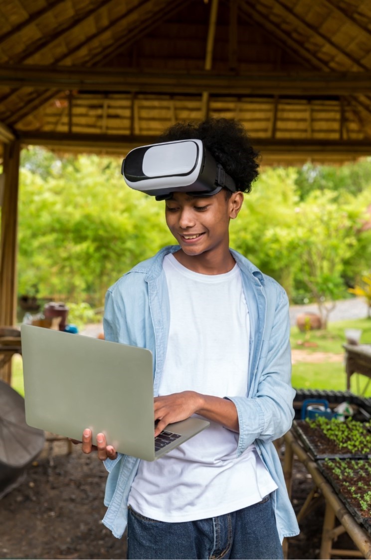 Boy with computer and VR headset outside